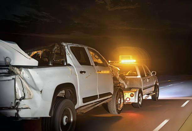 24/7 emergency tow truck with hazard lights on I-10 highway shoulder in New Orleans