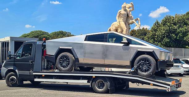 Specialized flatbed tow truck transporting an electric vehicle safely in New Orleans